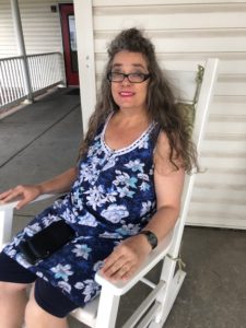 woman relaxing in rocking chair outside stephens farm. Adeo Brain Injury Services